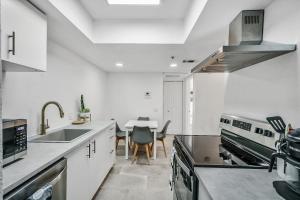 a kitchen with a sink and a table with chairs at Condo close to Strip and Raiders Stadium in Las Vegas