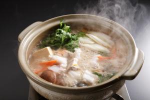 una olla de sopa con carne y verduras en Hotel Sumire ふぐ料理を愉しむ料理宿 en Shimonoseki
