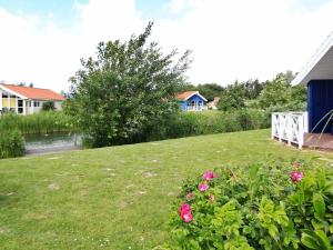 a yard with pink flowers and a white fence at 12 person holiday home in Otterndorf in Otterndorf