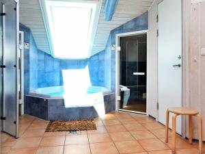 オッテルンドルフにある12 person holiday home in Otterndorfの青いバスルーム(バスタブ、シンク付)