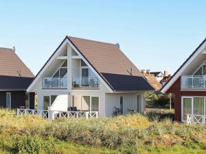 une maison blanche avec un toit marron dans l'établissement Two-Bedroom Holiday home in Wendtorf 1, à Wendtorf