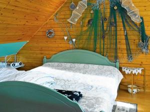 6 person holiday home in ASKER N في ستينانغسوند: غرفة نوم بسرير اخضر في جدار خشبي