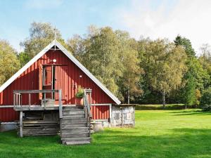 a red barn sitting in a green field at 6 person holiday home in ASKER N in Stenungsund