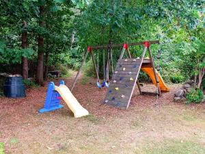 un parque infantil con un tobogán y un marco de escalada en 11 person holiday home in S LVESBORG, en Hällevik
