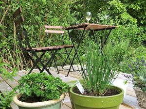 una mesa y una silla en un jardín con plantas en 11 person holiday home in S LVESBORG, en Hällevik