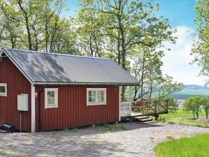 une maison rouge avec un toit métallique dans l'établissement 4 person holiday home in Sl inge, à Ugglarp