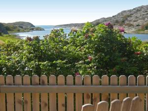 a wooden fence with a view of the water at 9 person holiday home in H LLEVIKSSTRAND in Hälleviksstrand