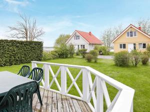 a deck with a table and chairs and a house at 8 person holiday home in Gelting in Gelting