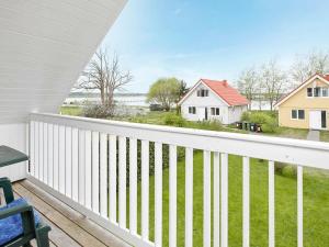 ゲルティングにある8 person holiday home in Geltingの白いフェンスが備わるバルコニーから庭の景色を望めます。