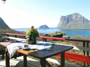 a picnic table on a deck with a view of the ocean at 5 person holiday home in LEKNES in Leknes