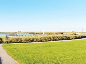 a path through a grassy field next to a body of water at 6 person holiday home in Wendtorf in Wendtorf