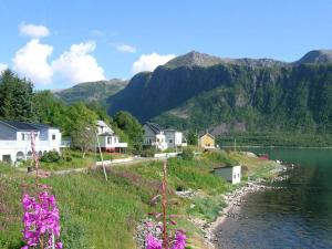a village with houses and a lake and mountains at 10 person holiday home in Kaldfarnes in Sifjord