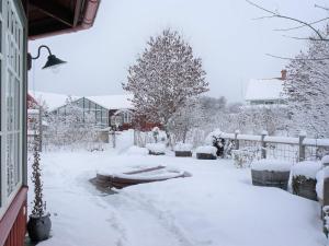 a yard covered in snow next to a house at 6 person holiday home in BODAFORS in Västrahyn