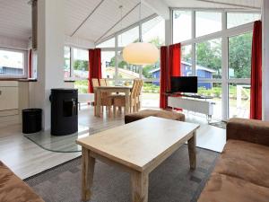 a living room with a table and a living room withwindows at Three-Bedroom Holiday home in Grömitz 15 in Grömitz
