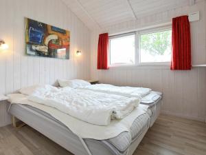 1 cama blanca grande en una habitación con ventana en Three-Bedroom Holiday home in Grömitz 15, en Grömitz