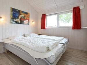 ein großes weißes Bett in einem Zimmer mit Fenster in der Unterkunft Three-Bedroom Holiday home in Grömitz 15 in Grömitz