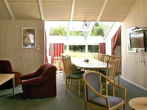 a room with a table and chairs and a television at 12 person holiday home in Otterndorf in Otterndorf