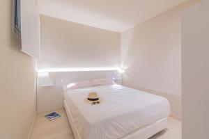 プラヤ・デアロにあるDaro Apartmentsのベッドルーム(ベッド、帽子付)