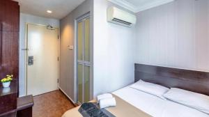 a bedroom with a large bed and a bathroom at Hotel Duke in Singapore