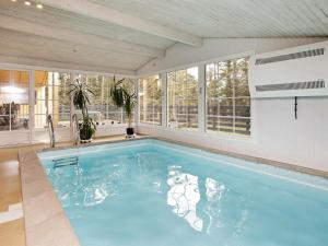 a large swimming pool in a room with windows at 8 person holiday home in Ringk bing in Klegod
