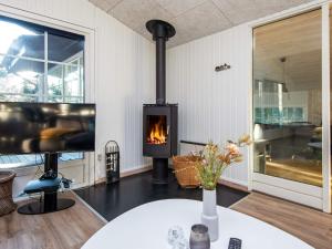 a fireplace in a living room with a table at 8 person holiday home in Ringk bing in Klegod