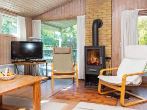 a living room with a fireplace and a tv at 6 person holiday home in Glesborg in Bønnerup
