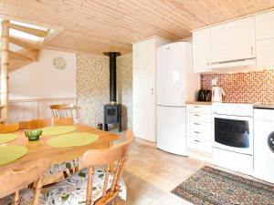 ハンブルクスンドにある4 person holiday home in Hamburgsundのキッチン(木製テーブル付)、キッチン(白い家電製品付)