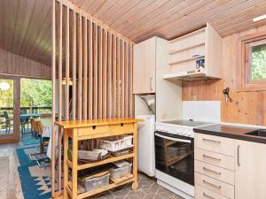 uma cozinha com armários brancos e uma mesa em 6 person holiday home in Glesborg em Bønnerup