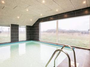 una piscina con vistas al campo a través de las ventanas en Ten-Bedroom Holiday home in Brovst, en Brovst