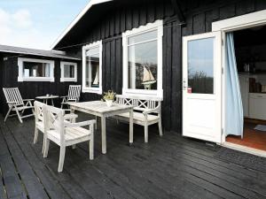 スケーエンにあるPeaceful Holiday Home in Skagen near Seaの家の中のパティオ(テーブル、椅子付)