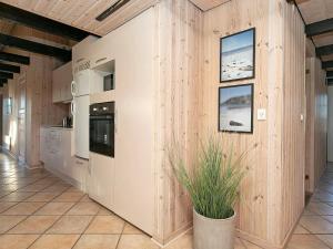 a kitchen with wooden walls and a plant in a pot at 8 person holiday home in Ringk bing in Klegod
