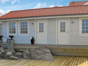 Rönnängにある2 person holiday home in R nn ngの白いドアと木製のデッキが備わる家
