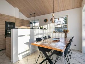 a kitchen with a wooden table and chairs at 8 person holiday home in L s in Læsø