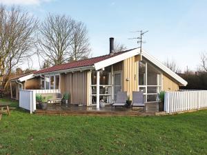 a small house with a deck and two chairs at 10 person holiday home in Humble-By Traum in Humble
