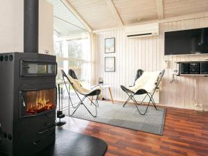 a living room with a fireplace and chairs at 10 person holiday home in Humble-By Traum in Humble