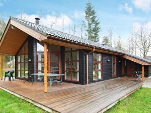 a house with a wooden deck with a table at 8 person holiday home in Skals in Hjarbæk