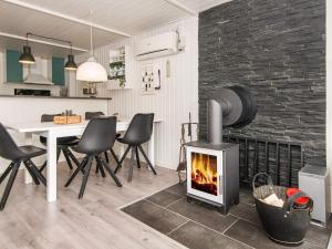 a living room with a fireplace and a table and chairs at 5 person holiday home in Hemmet in Falen