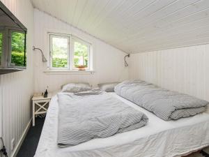 two beds in a white room with two windows at 5 person holiday home in Hemmet in Falen