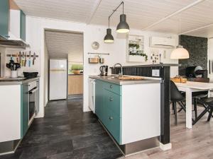a kitchen with a sink and a table in it at 5 person holiday home in Hemmet in Falen