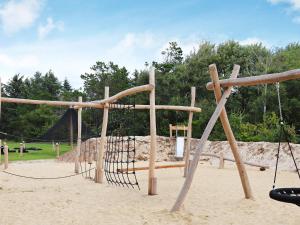 a playground with a swing set in the sand at 12 person holiday home in Ringk bing in Søndervig