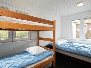 two bunk beds in a room with two windows at Four-Bedroom Holiday home in Vinderup 2 in Vinderup