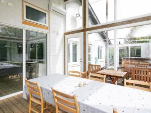 porche con mesa blanca, sillas y ventanas en Four-Bedroom Holiday home in Vinderup 2, en Vinderup