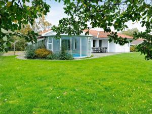 a house with a lawn in front of it at 8 person holiday home in Juelsminde in Sønderby