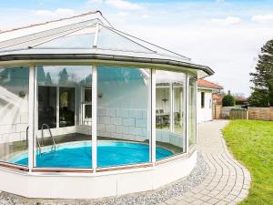 a glass house with a pool inside of it at 8 person holiday home in Juelsminde in Sønderby