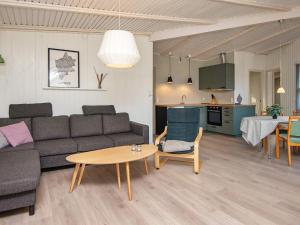 ArrildにあるFour-Bedroom Holiday home in Toftlund 6のリビングルーム(ソファ、テーブル付)、キッチンが備わります。