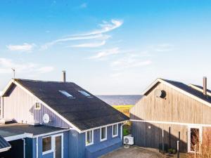 two houses with the ocean in the background at 7 person holiday home in Hemmet in Falen