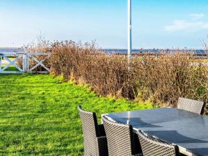 a table and chairs in front of the beach at 7 person holiday home in Hemmet in Falen