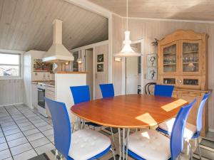 ロッケンにある6 person holiday home in L kkenのキッチン、ダイニングルーム(木製テーブル、青い椅子付)