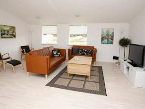 sala de estar con muebles de cuero marrón y TV en 16 person holiday home in Brovst, en Brovst