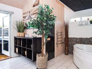a bathroom with a tree in the middle of it at 6 person holiday home in Tarm in Hemmet